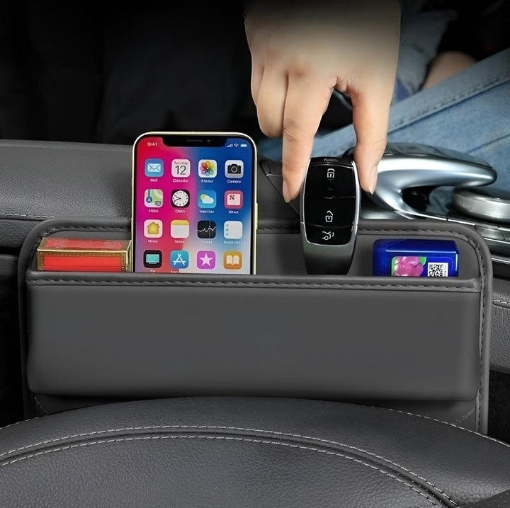 Sea Dragon Dreams leather car seat gap organizer holding a smartphone, car key, and small items in a vehicle console.