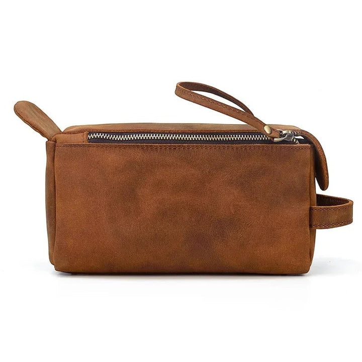 Sea Dragon Dreams brown handmade leather toiletry bag with a side carry handle and zipper closure for travel.
