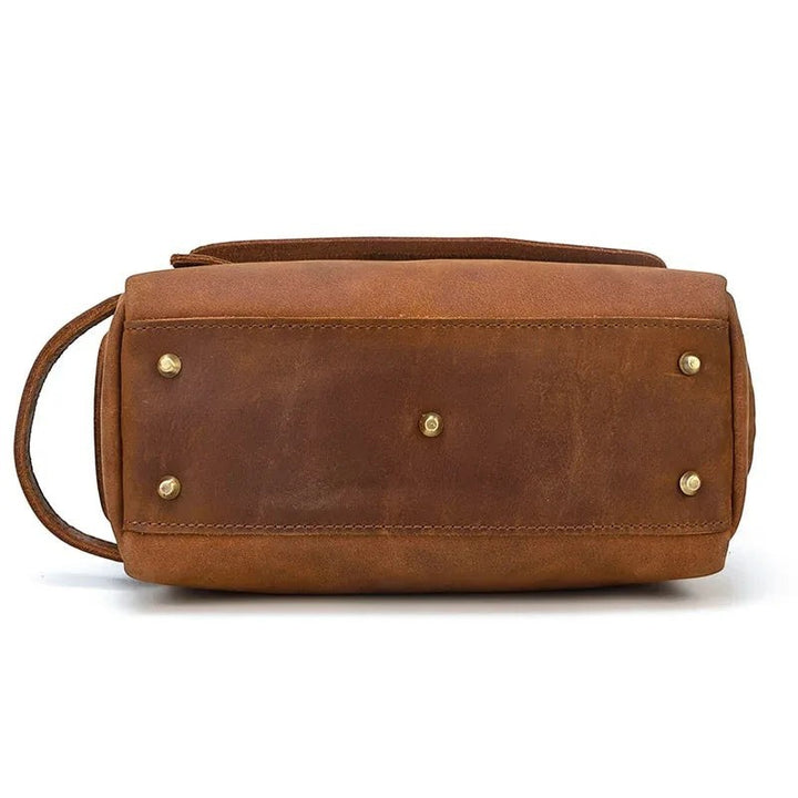 Sea Dragon Dreams brown leather toiletry bag bottom view with protective brass feet and side carry handle