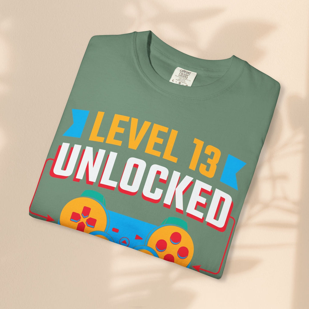 Sea Dragon Dreams Level 13 Unlocked gamer t-shirt in sage green cotton with a retro-style colorful controller graphic