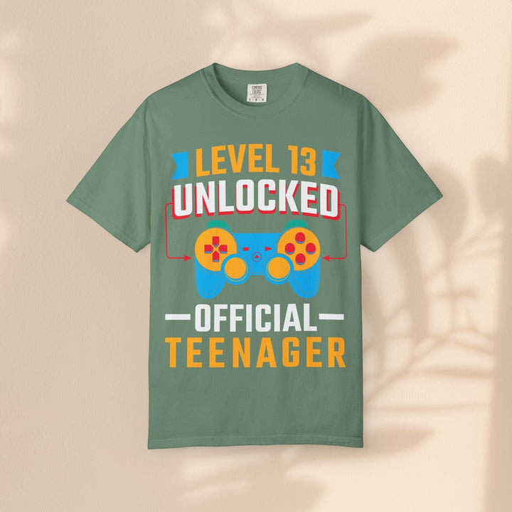 Sea Dragon Dreams Level 13 Unlocked gamer t-shirt in sage green cotton with a colorful retro gaming controller graphic.