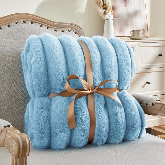 Sea Dragon Dreams BEDELITE light blue faux rabbit fur throw blanket with 3D striped texture tied with a brown ribbon.