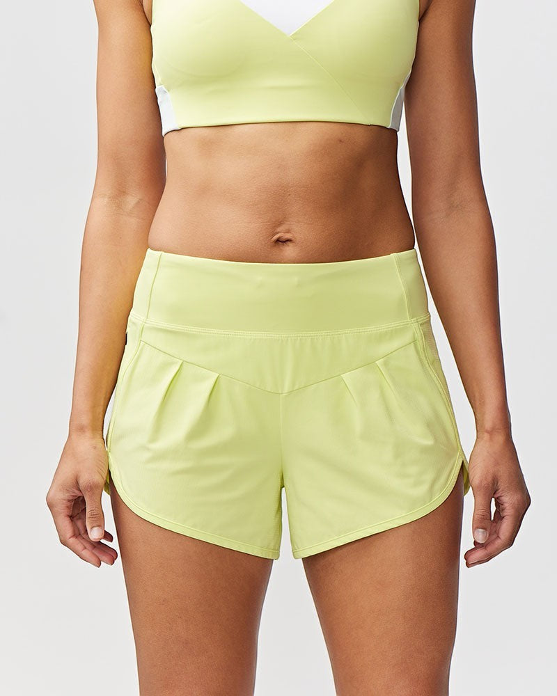 Sea Dragon Dreams Sheva women's high rise running shorts in lime green with pleated detail and a flat knit waistband.