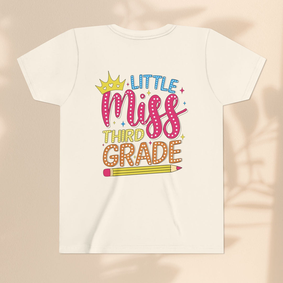 Sea Dragon Dreams youth t-shirt in cream cotton featuring a Little Miss Third Grade graphic with a crown and pencil.