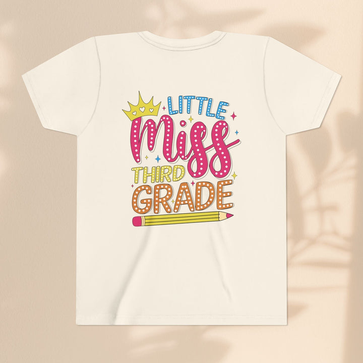 Sea Dragon Dreams youth t-shirt in cream cotton featuring a Little Miss Third Grade graphic with a crown and pencil.
