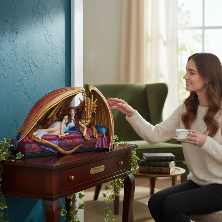 Sea Dragon Dreams Inner Sanctum figurine featuring a maiden and dragon on a chaise, displayed on a wooden table.