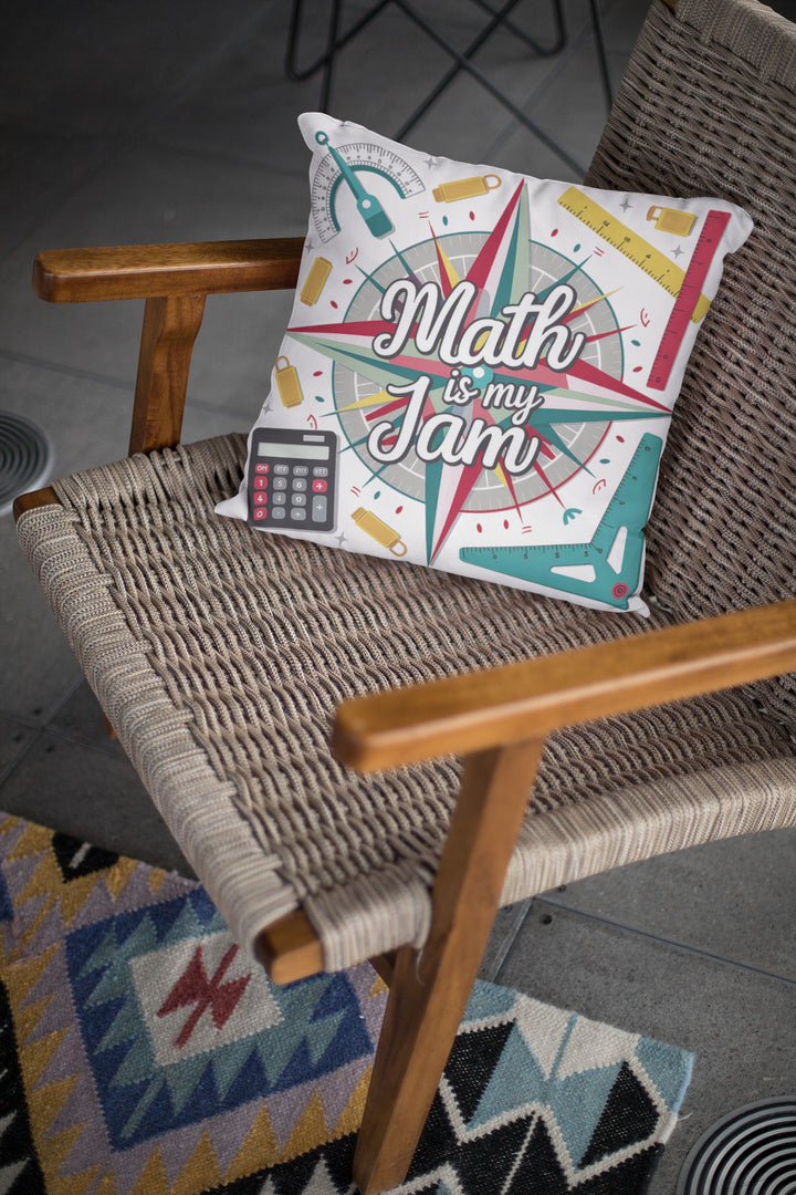 Sea Dragon Dreams Math is My Jam square faux suede pillow with colorful math-themed graphics on a woven chair.