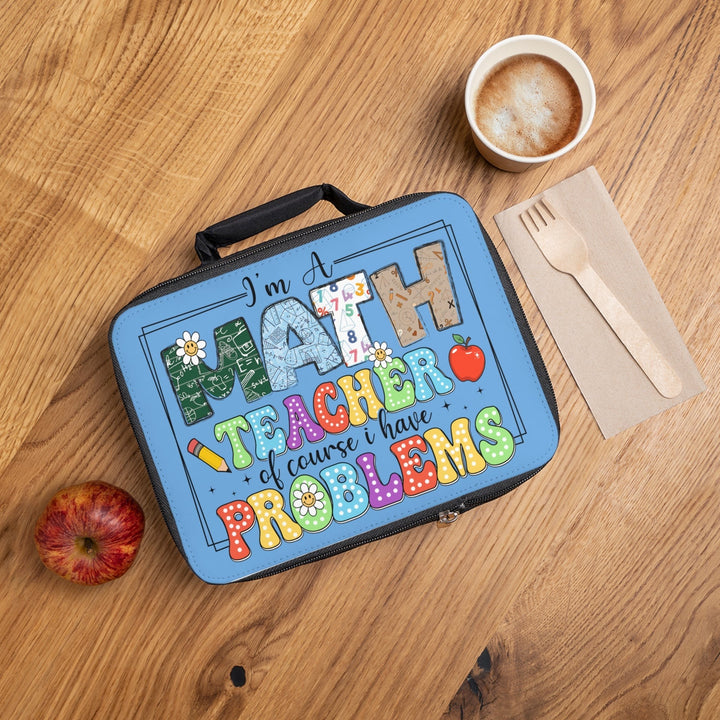 Sea Dragon Dreams insulated lunch bag with Math Teacher Have Problems print on a wooden table with coffee and apple.