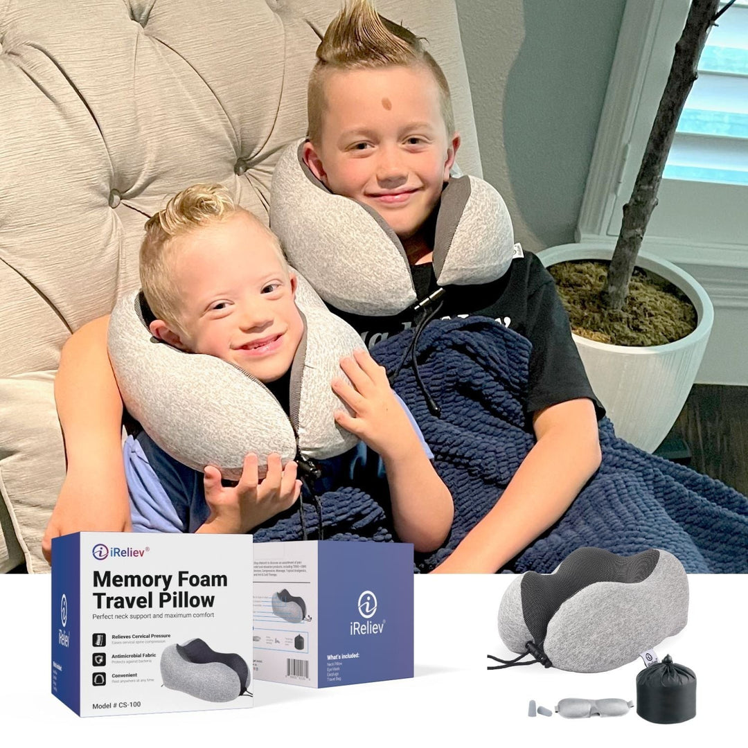 Two boys wearing Sea Dragon Dreams memory foam travel pillows while sitting on a couch with product packaging