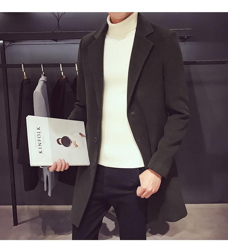 Sea Dragon Dreams men's dark green cotton trench coat with a turn-down collar worn over a white turtleneck sweater.