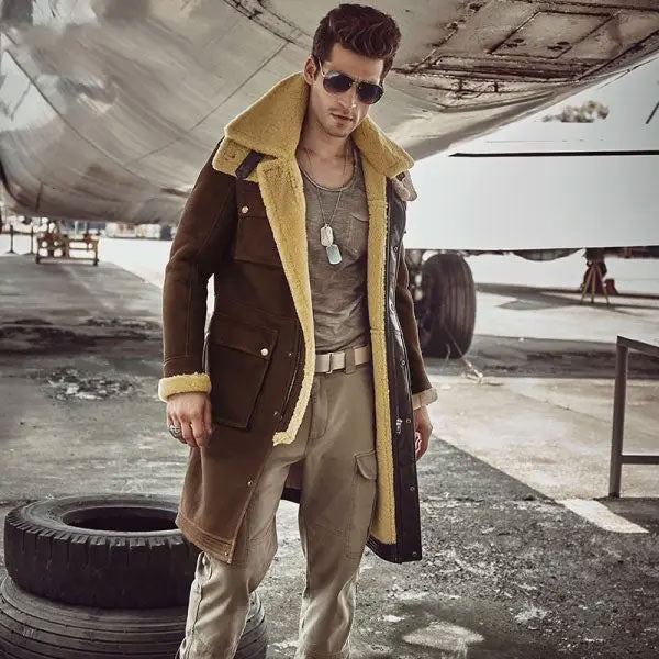 Sea Dragon Dreams men's brown shearling parka with yellow wool lining and hood, worn by a model near an aircraft.