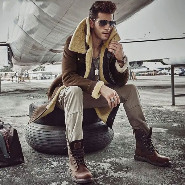 Sea Dragon Dreams men's brown shearling parka with sheepskin wool lining worn by a model in sunglasses near an aircraft