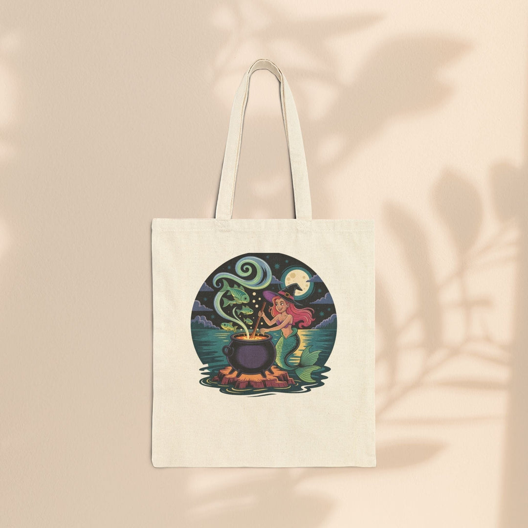 Sea Dragon Dreams natural cotton canvas tote bag featuring a whimsical mermaid stirring a magical cauldron illustration