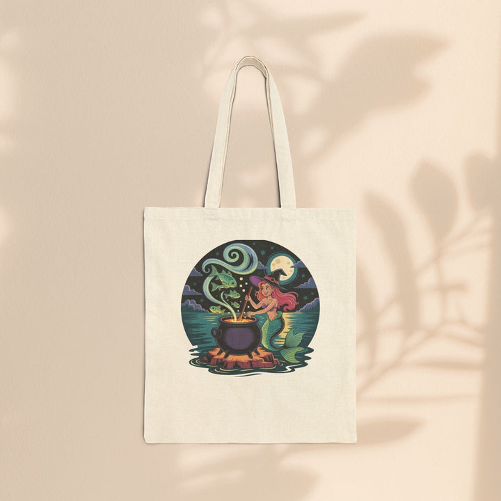 Sea Dragon Dreams natural cotton canvas tote bag featuring a whimsical mermaid stirring a magical cauldron illustration