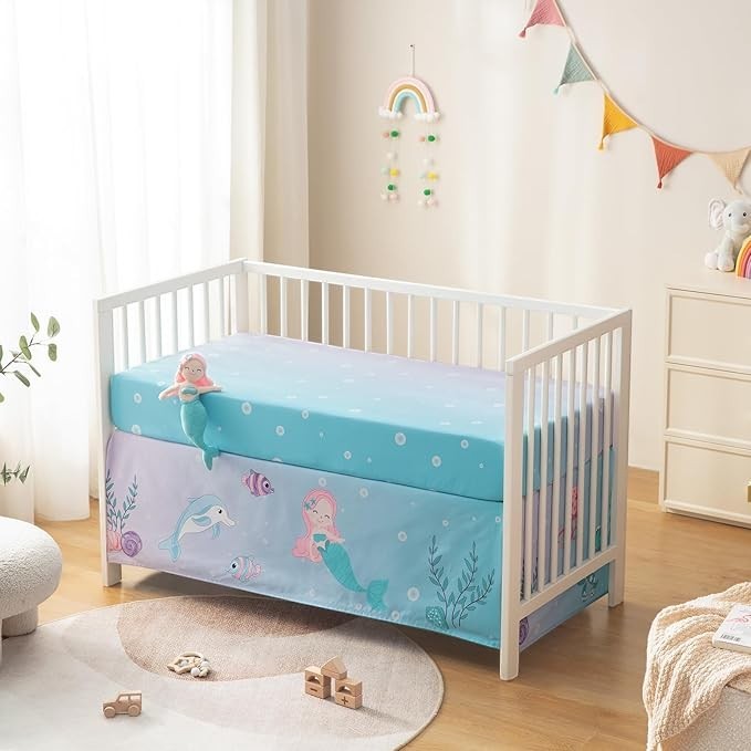 Sea Dragon Dreams 4-piece mermaid crib bedding set with cartoon quilt, fitted sheet, skirt, and plush mermaid toy.