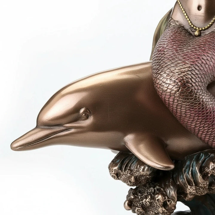 Sea Dragon Dreams polystone mermaid and dolphin figurine featuring a bronze finish and detailed wave base