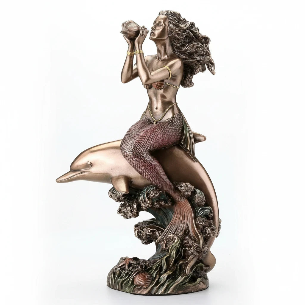 Sea Dragon Dreams polystone mermaid and dolphin figurine featuring a siren blowing a seashell on a cresting wave.