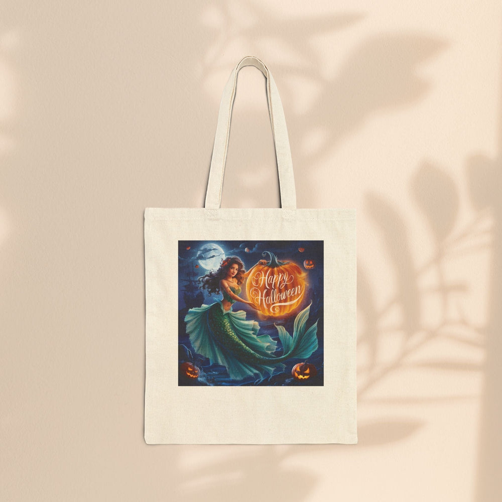 Sea Dragon Dreams natural cotton canvas tote bag featuring a mermaid holding a glowing pumpkin for Halloween.