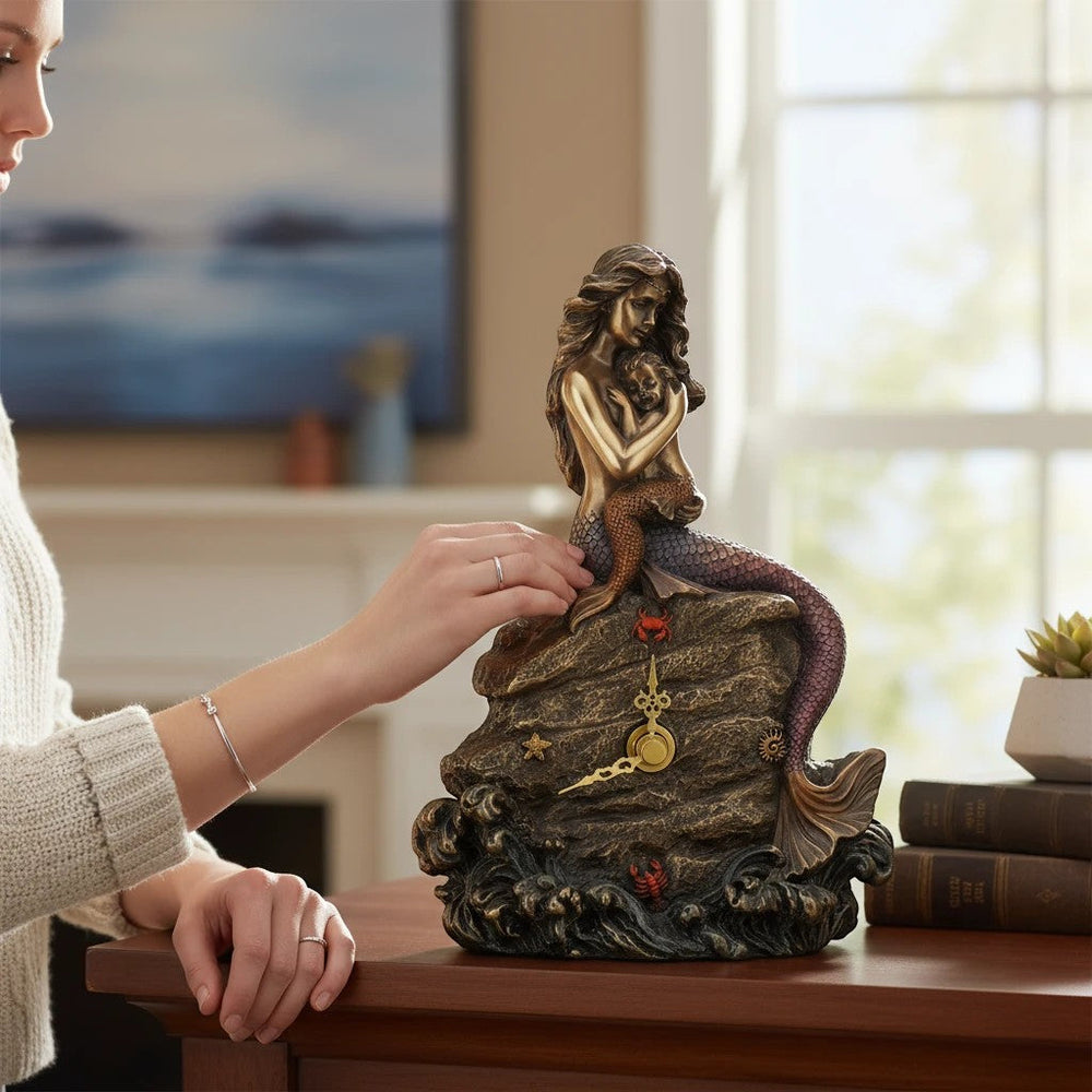 Sea Dragon Dreams mermaid mother and baby clock featuring a sculpted bronze-toned figure on a rocky ocean wave base.
