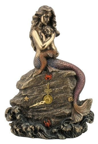 Sea Dragon Dreams mermaid mother and baby clock featuring a sculpted bronze-toned figure on a rocky ocean base.