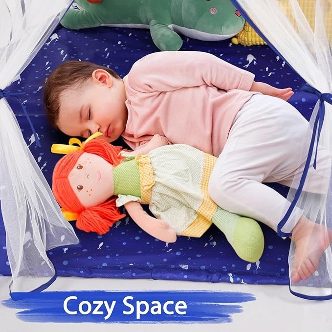 A child sleeping inside a Sea Dragon Dreams blue mermaid play tent with a doll on a soft, patterned floor mat.