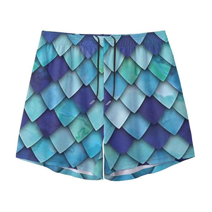 Sea Dragon Dreams men's swim shorts featuring a vibrant blue and teal mermaid scale pattern with an elastic waistband.