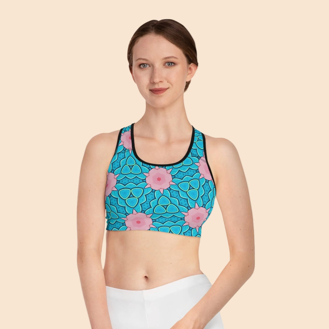Sea Dragon Dreams Mermaid’s Garden seamless sports bra with blue ocean floral print and black trim on a model.