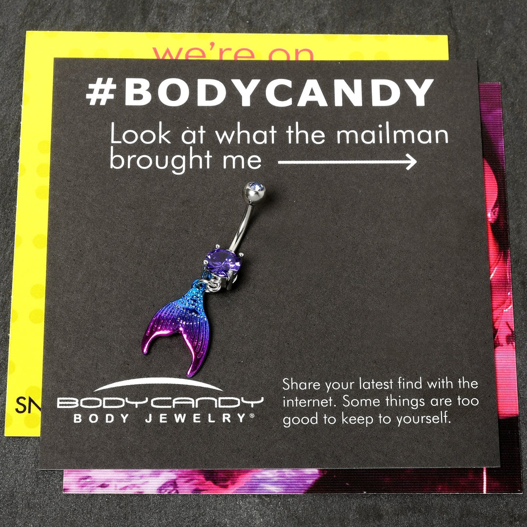 Sea Dragon Dreams purple mermaid tail belly ring with a pink and aqua enamel finish and a sparkling purple gemstone.