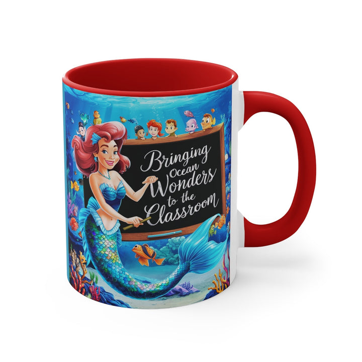 Sea Dragon Dreams ceramic accent mug with a red handle and mermaid teacher illustration in an underwater classroom.