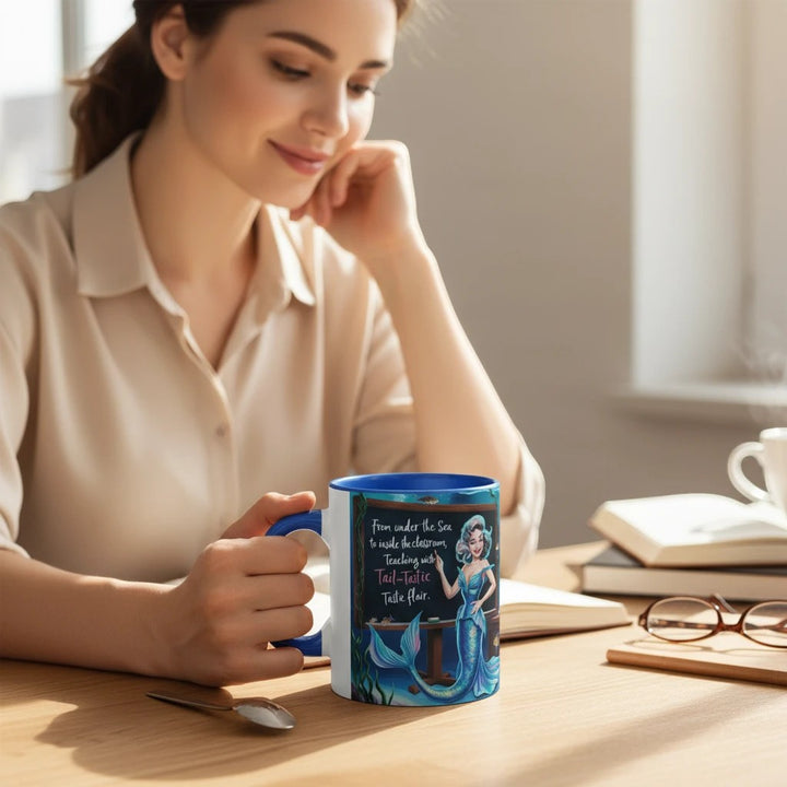 Sea Dragon Dreams 11oz ceramic accent mug with blue handle and mermaid teacher design held by a woman at a desk