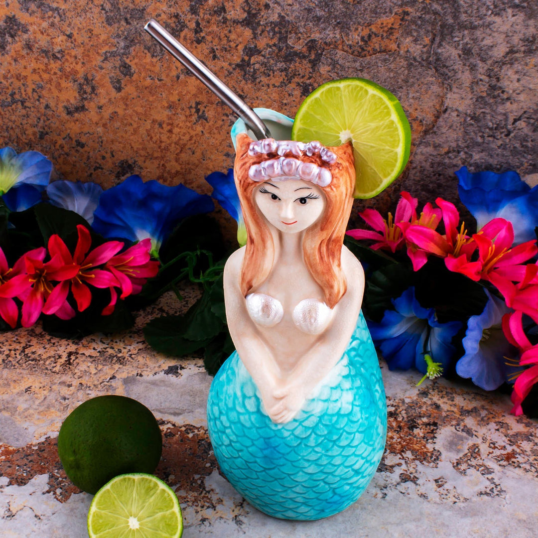 Sea Dragon Dreams 16 oz ceramic mermaid tiki mug with hand-painted tail and hair, styled with lime and tropical flowers.