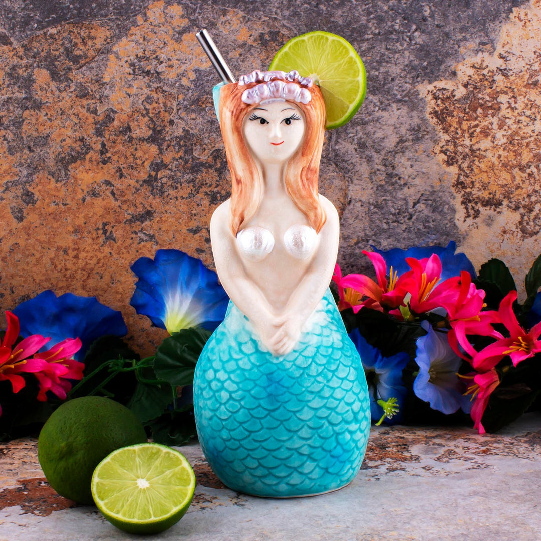 Sea Dragon Dreams hand-painted ceramic mermaid tiki mug with tropical cocktail, lime garnish, and floral background.