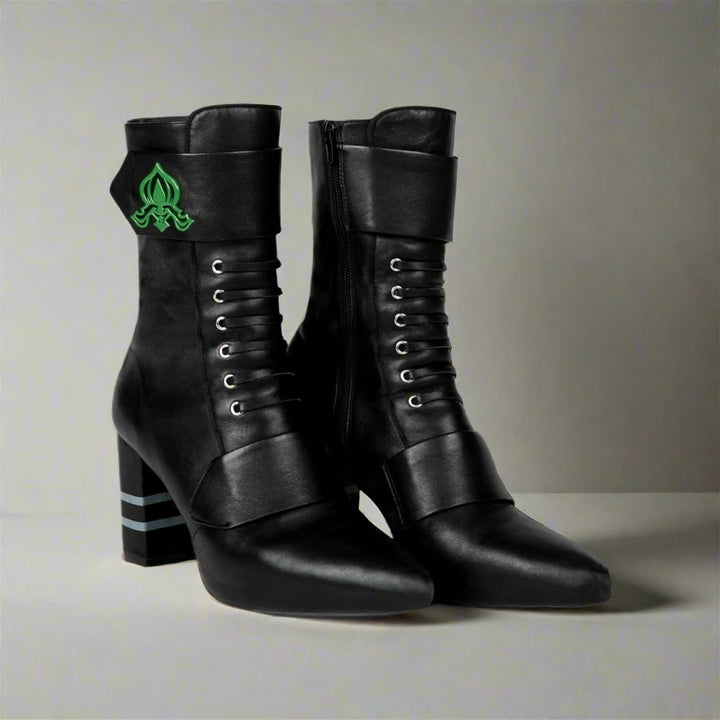 Sea Dragon Dreams Michaela V Marta black leather knee-high boots with green emblem detail and block heels.