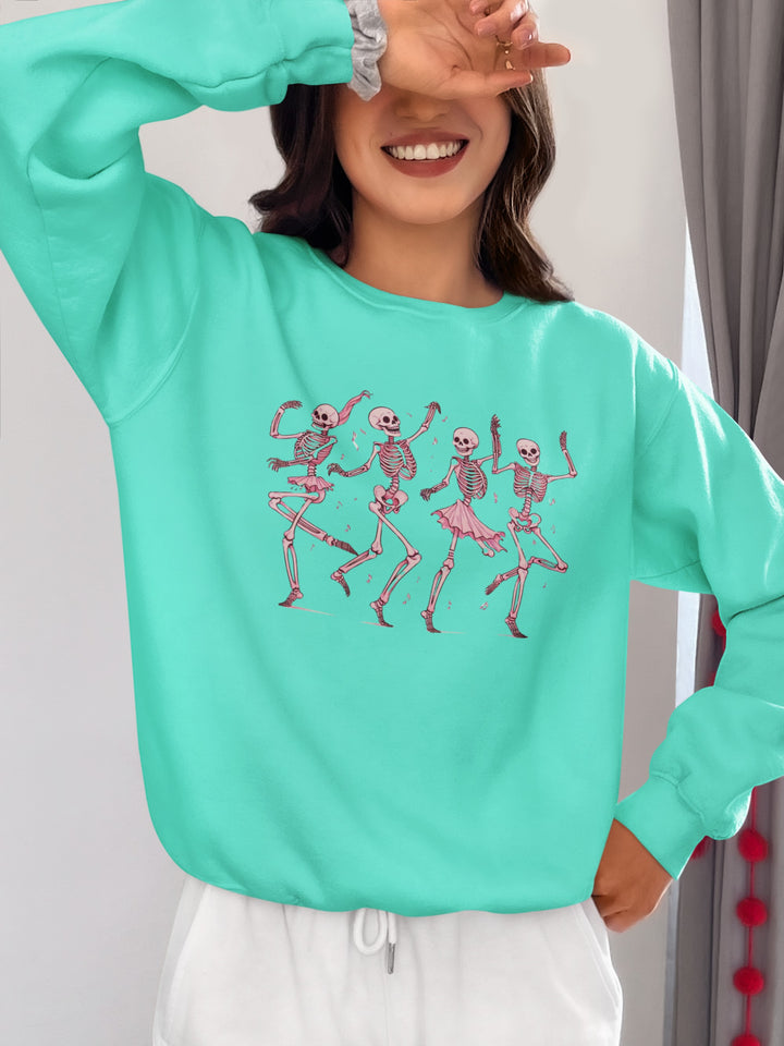 Sea Dragon Dreams mint green crewneck sweatshirt featuring a graphic of four dancing skeletons in pink tutus.