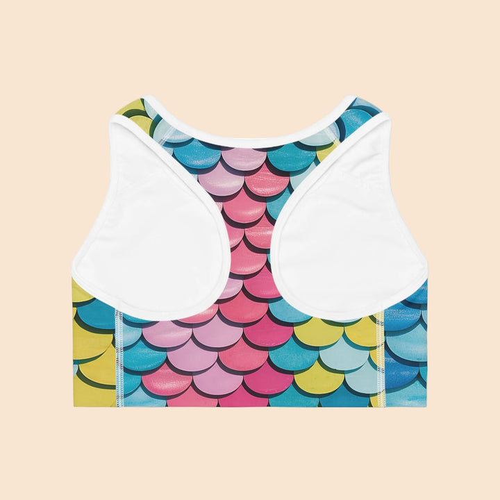 Sea Dragon Dreams MNMS seamless sports bra with a vibrant multi-colored mermaid scale print and white racerback trim.