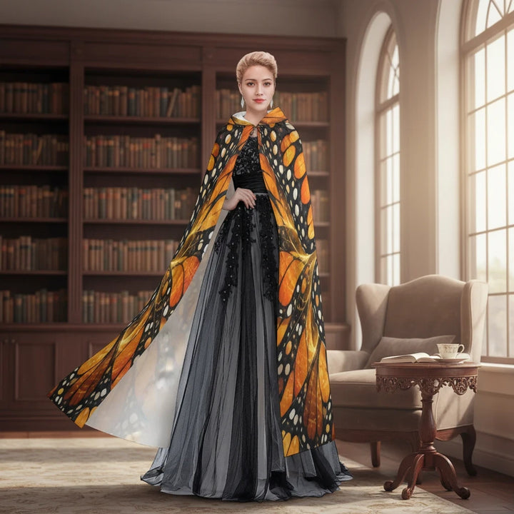 Sea Dragon Dreams unisex hooded cloak featuring a vibrant orange and black monarch butterfly wing pattern in a library.