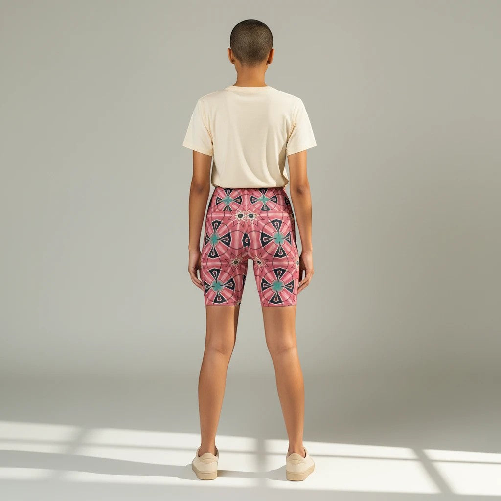 Model wearing Sea Dragon Dreams Mystic Circles floral workout shorts with a pink circular pattern and beige t-shirt.