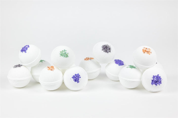 Sea Dragon Dreams collection of white spherical bath bombs topped with colorful natural salts and dried botanicals.