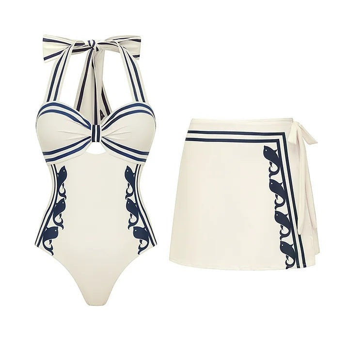 Sea Dragon Dreams cream and navy halter one-piece swimsuit with matching wrap skirt and nautical fish print details.