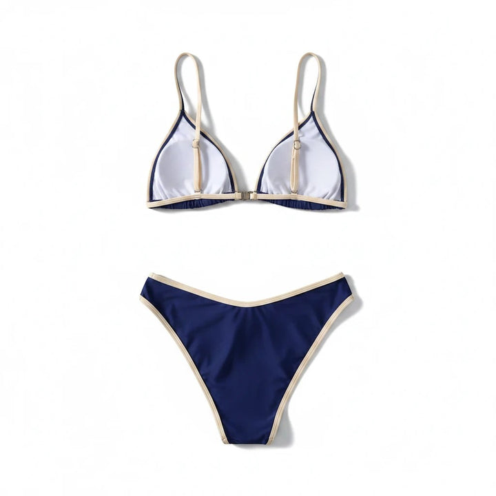 Sea Dragon Dreams navy blue bikini set with cream contrast trim, featuring a triangle top and low-rise bottoms.