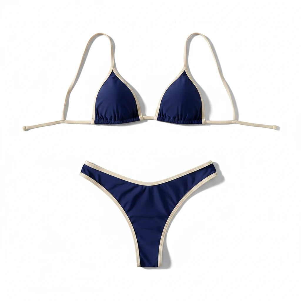 Sea Dragon Dreams navy blue bikini set with cream contrast trim, featuring a triangle top and low-rise bottoms.