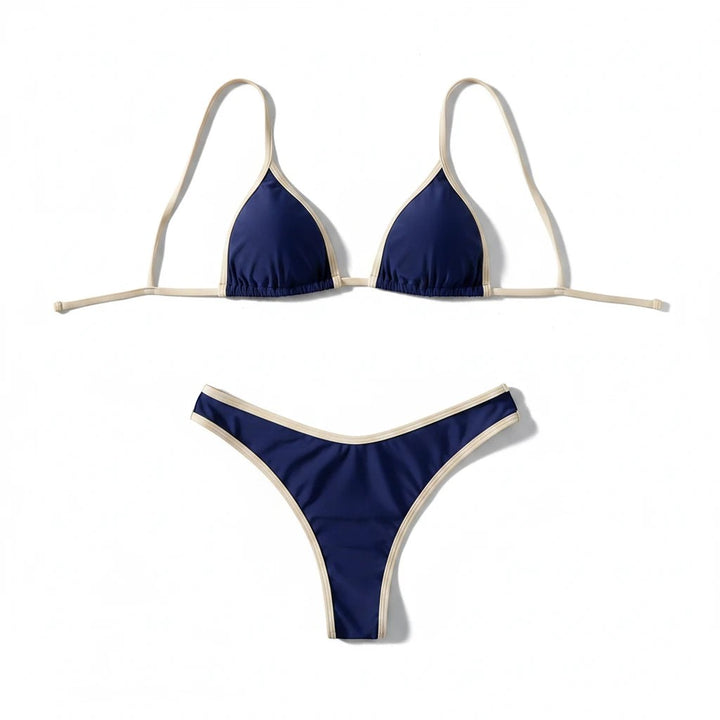 Sea Dragon Dreams navy blue bikini set with cream contrast trim, featuring a triangle top and low-rise bottoms.