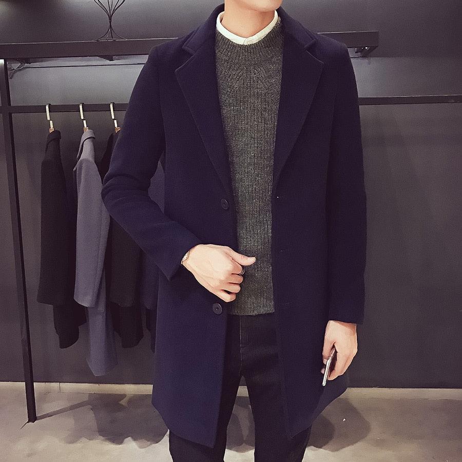 Sea Dragon Dreams men's navy blue cotton trench coat with a turn-down collar worn over a grey sweater in a shop