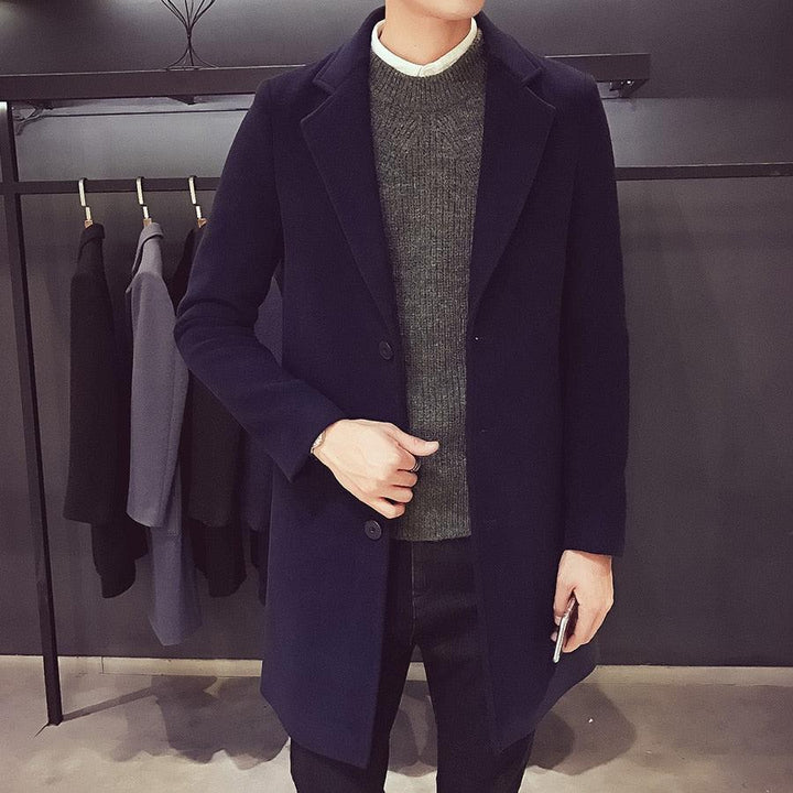 Sea Dragon Dreams men's navy blue cotton trench coat with a turn-down collar worn over a grey sweater in a shop