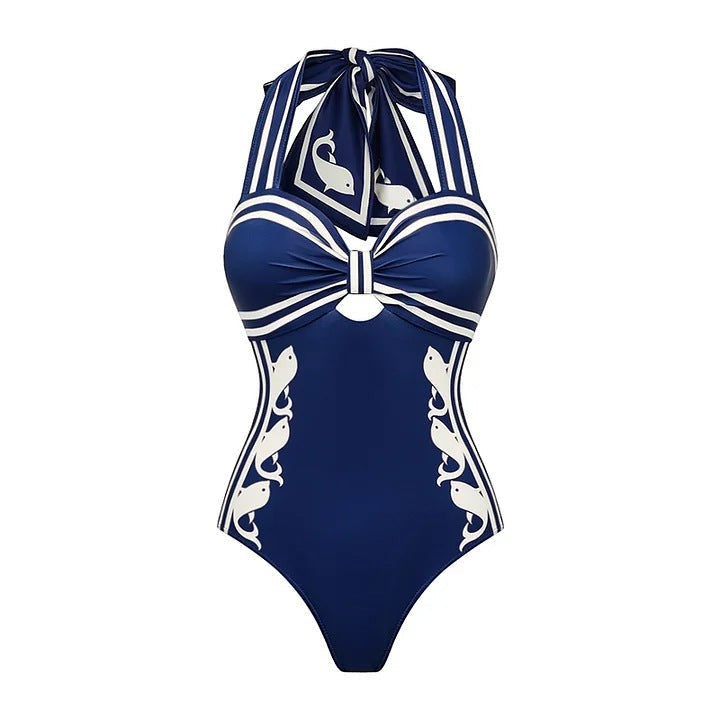 Sea Dragon Dreams navy blue halter one-piece swimsuit with white nautical stripes and whale print detailing.
