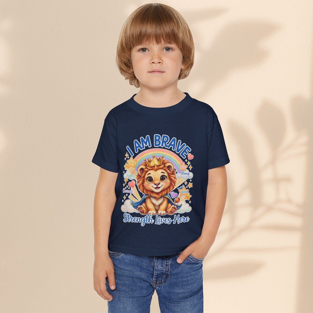 A young child wearing a navy blue Sea Dragon Dreams cotton t-shirt featuring a Leo Lion graphic and I Am Brave text.