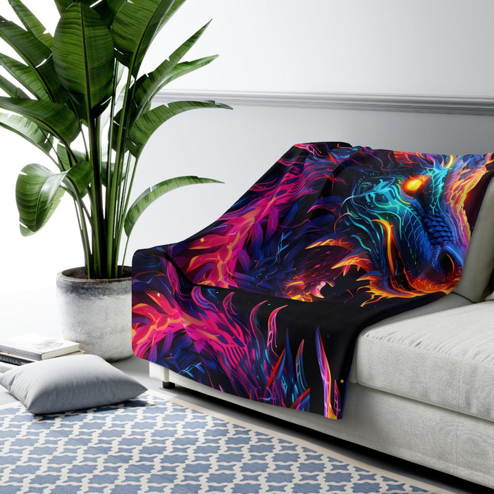 Sea Dragon Dreams neon dragon sherpa fleece blanket with vibrant fantasy artwork draped over a modern white sofa.
