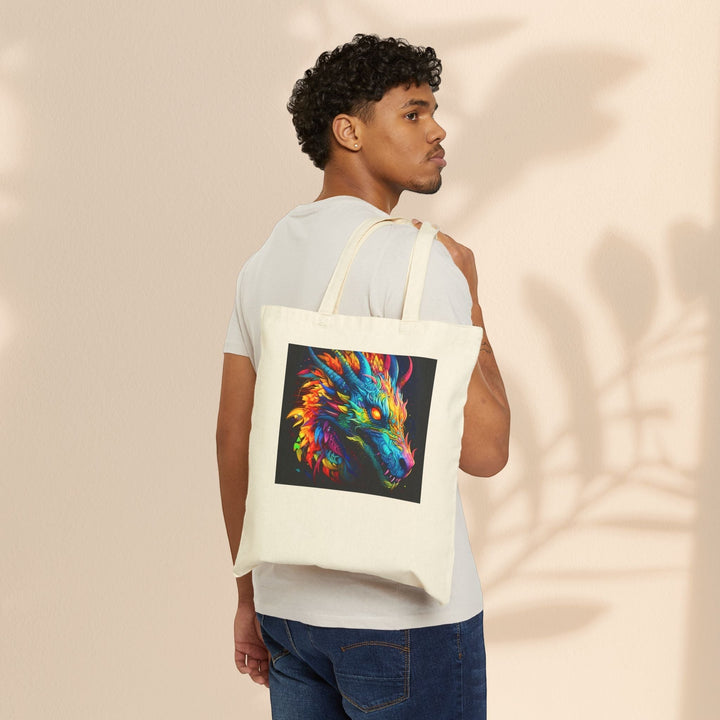 Man wearing a Sea Dragon Dreams natural cotton canvas tote bag with a vibrant neon dragon graphic on his shoulder