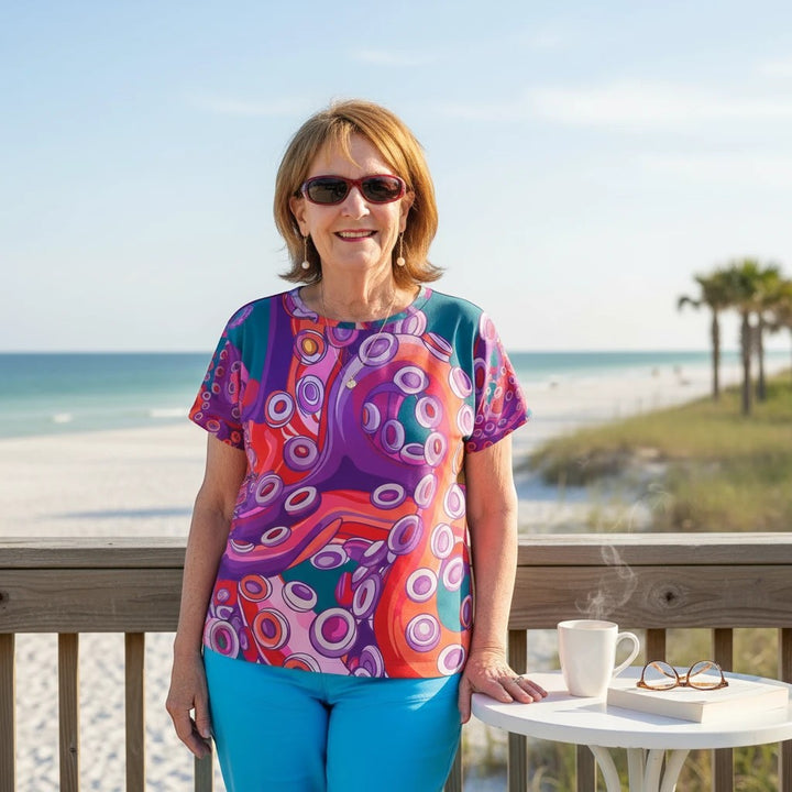 Sea Dragon Dreams women's sports jersey featuring a vibrant, artistic octopus print on a beach deck.