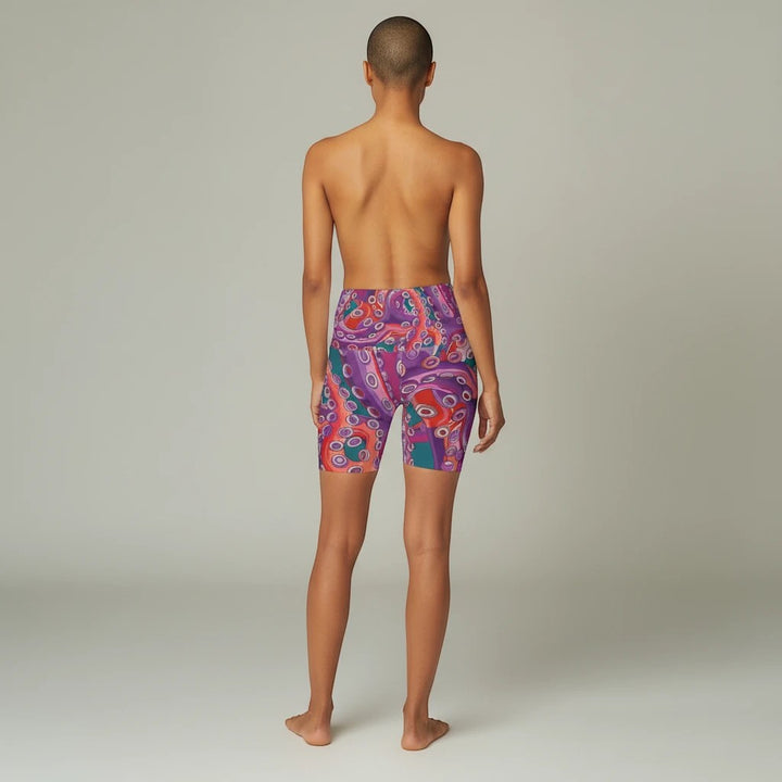 Sea Dragon Dreams high waisted yoga shorts with a vibrant purple and red octopus pattern on a model from behind